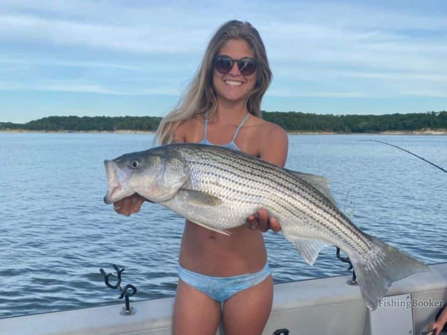 girl holding a striped bass